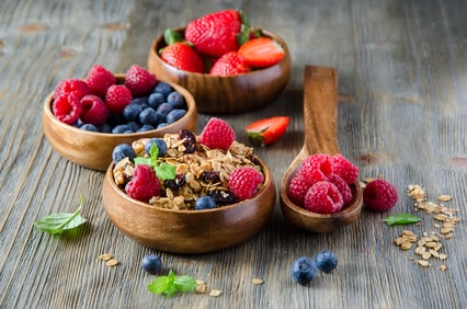 Fresh healthy breakfast with granola and berries, wooden backgro